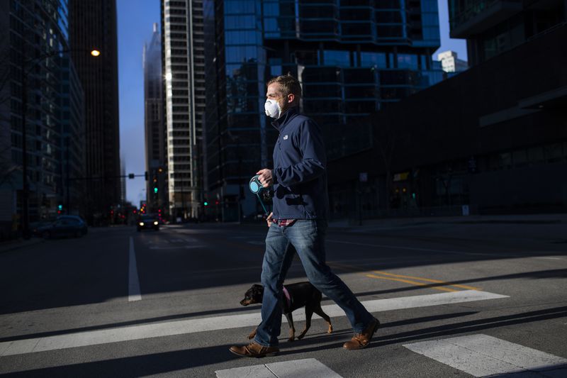 Jimmy Smart, 32, wears a mask while walking his dog in Chicago's Streeterville neighborhood on April 1, 2020.